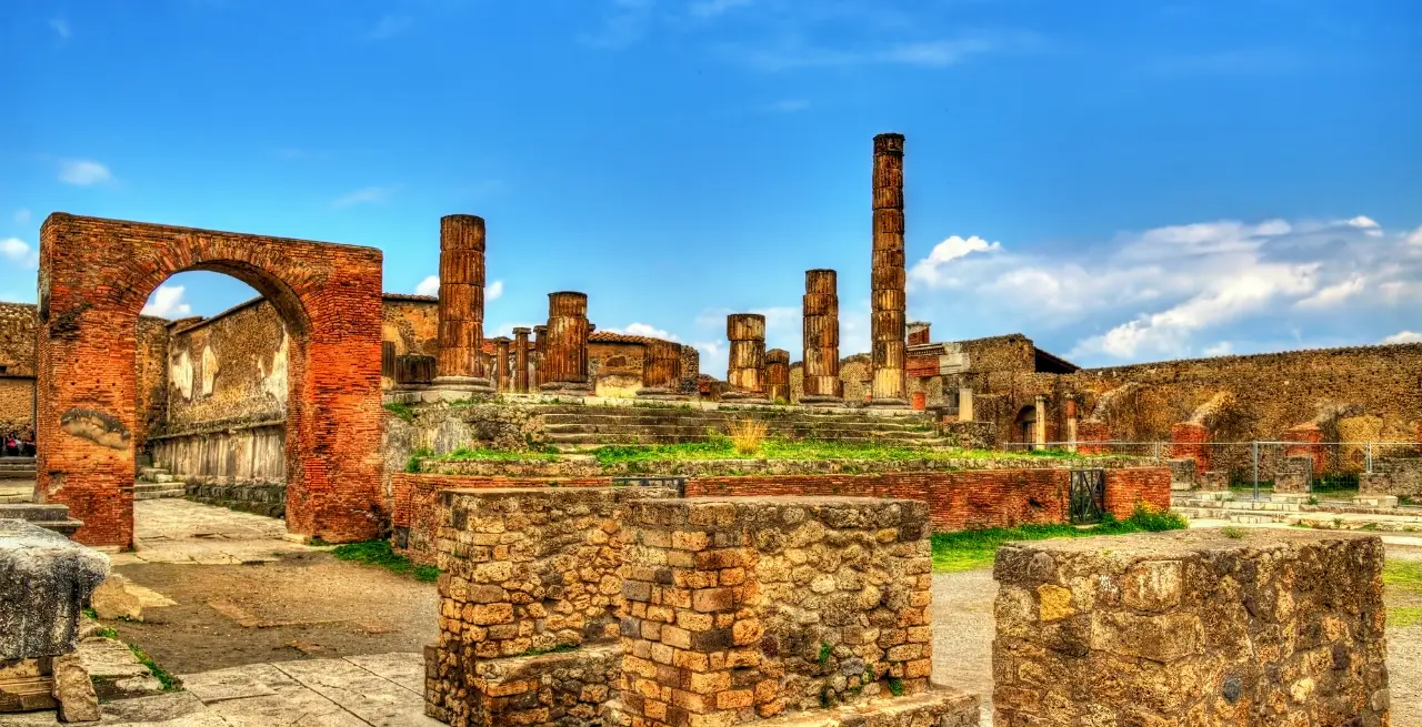 Ruinen des Tempels von Jupiter in Pompeji, Italien, mit gut erhaltenen Säulen und historischen Steinarbeiten unter blauem Himmel [Bildquelle: © Leonid Andronov | Canva]